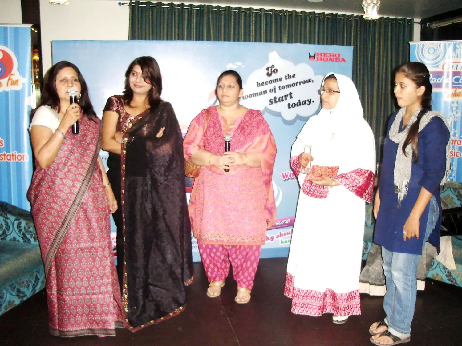 Group of men posing with large cartoon character inflatable figures at night outdoors